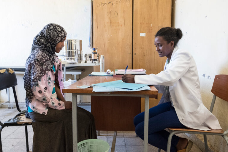 Eine Krankenschwester mit ihrer jungen Patientin.