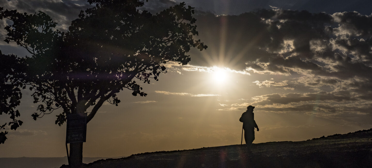 Sonnenuntergang in Äthiopien, Mann geht Feldweg entlang.