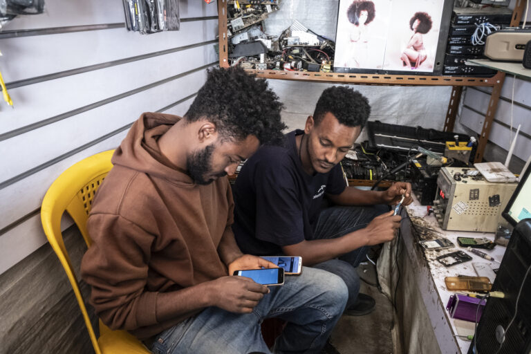 Projektgebiet Wore Illu. Bela Tesfaye, 24 (schwarzes T-Shirt) arbeitet in einem Handyreparatur-Geschäft in Wore Illu. Sein Chef heißt Eyouale Belate, 26