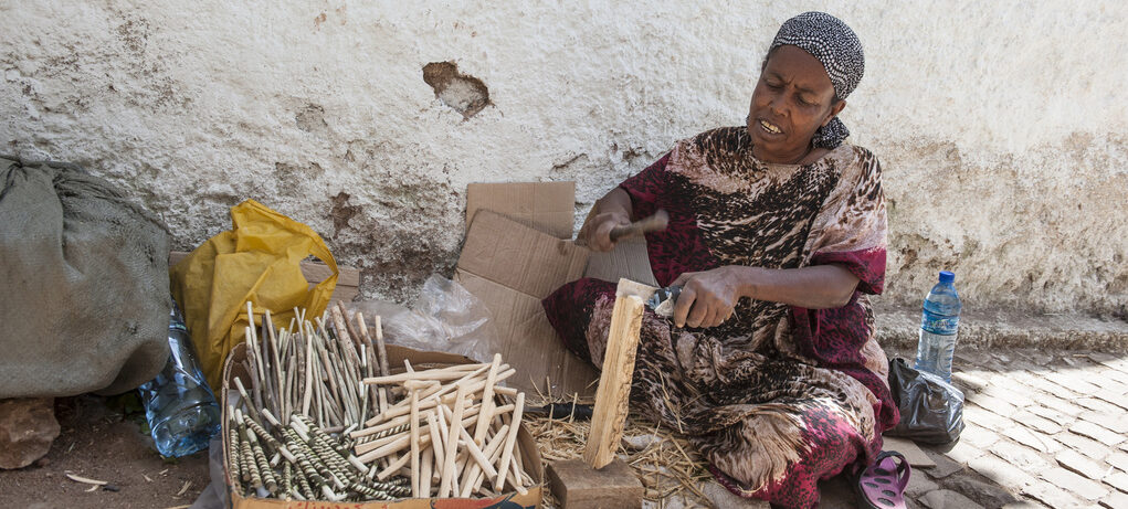 Harar. Ethiopia Sisay, 65. Sie sitzt in einer Seitenstraße in Harar auf dem Kopfsteinpflaster und schnitzt Zahlhölzer. Fotograf: Rainer Kwiotek